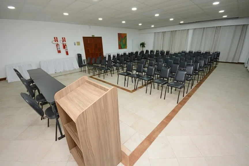 Sala de eventos equipada com auditório, mesa e púlpito